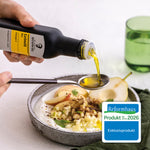 Leinöl wird auf einem Esslöffel gekippt. Unter dem Löffel befindet sich ein Quark-Mix mit Birnen & Äpfel.